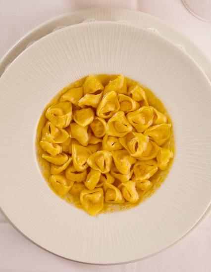 Tortellini in brodo in un piatto bianco, fotografati dall'alto alla Trattoria La Busa.