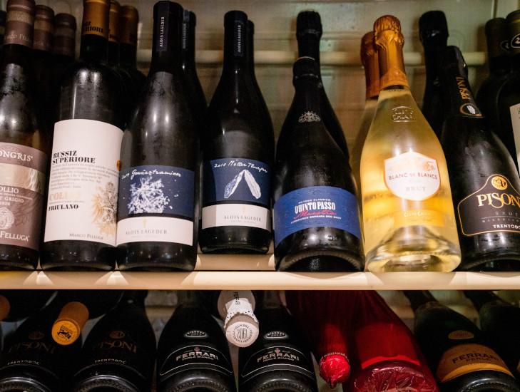 Bottiglie di vino esposte sugli scaffali della cantina della Trattoria La Busa.